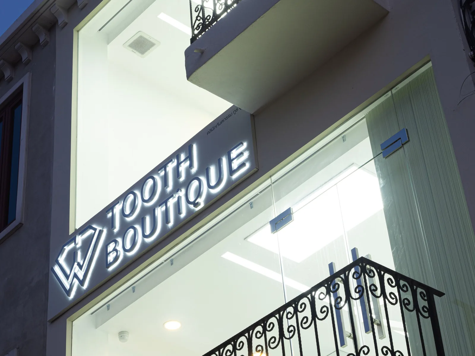 ป้ายชื่อ Tooth Boutique บนกระจกหน้าคลินิก