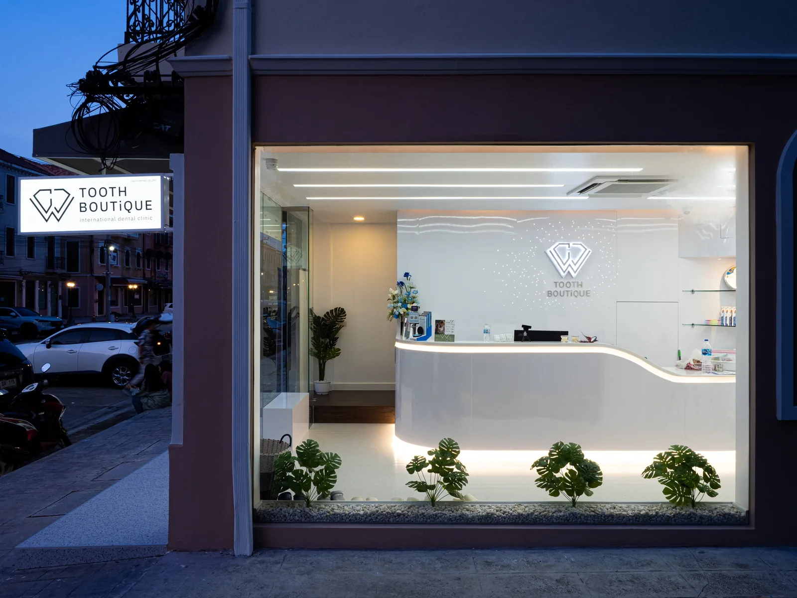 The storefront at dusk, lit from inside with the reception visible through the glass